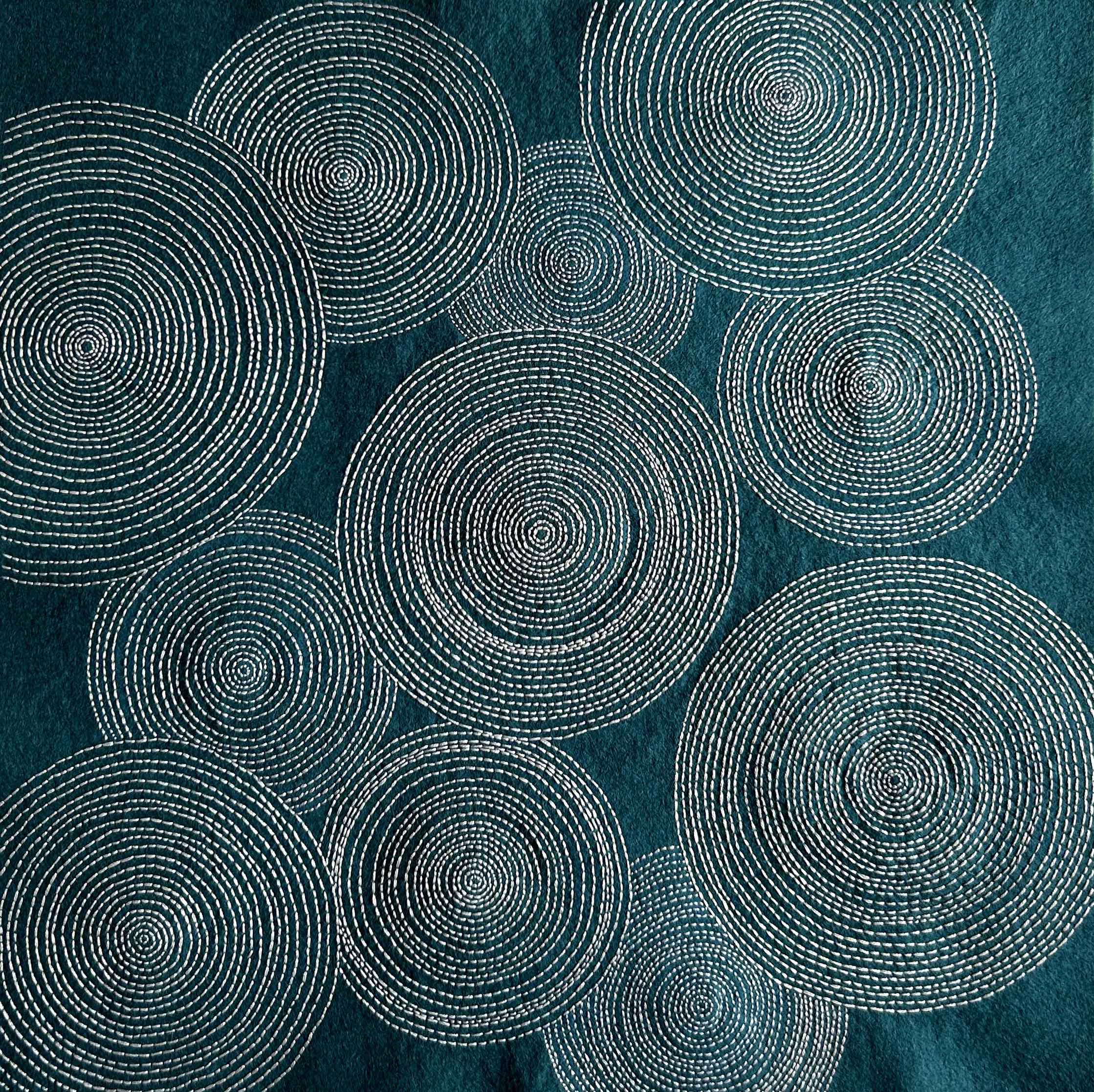 Photo of art white thread on teal felt