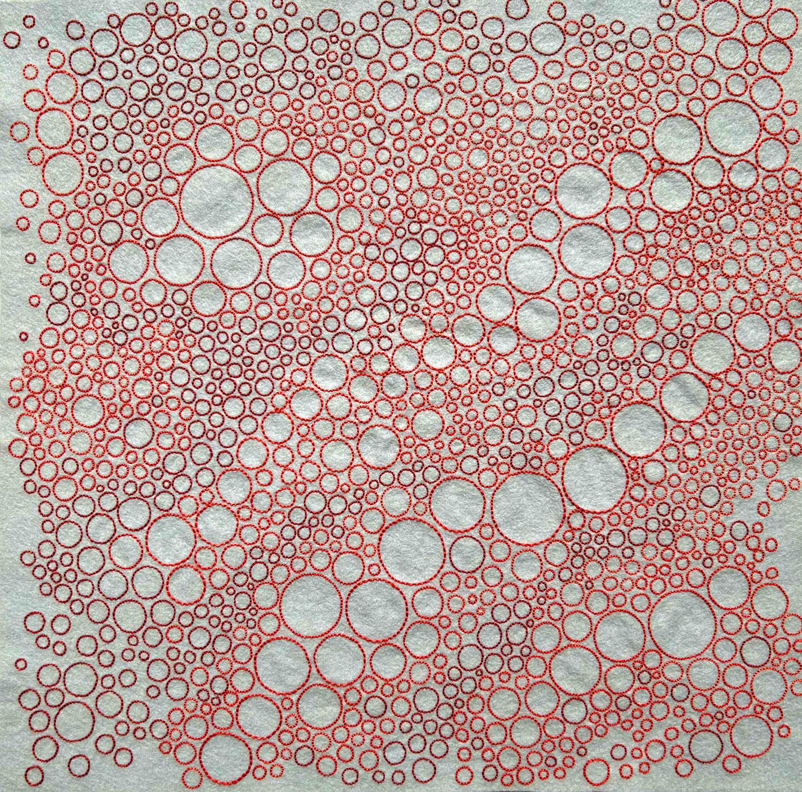 Photo of art coral, salmon, and terra cotta thread on silver felt
