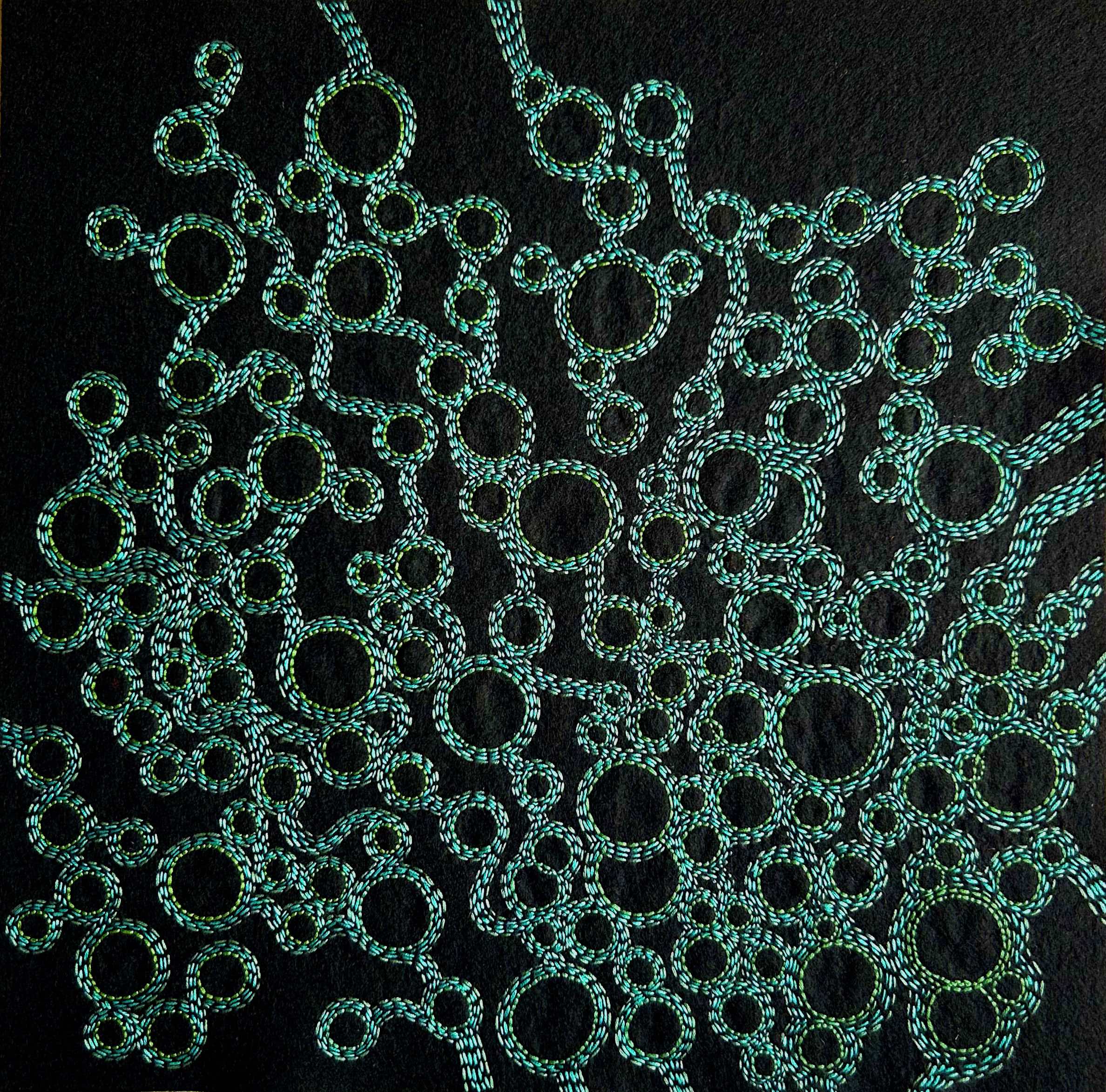 Photo of art celadon, teal green, and blue green thread on black felt